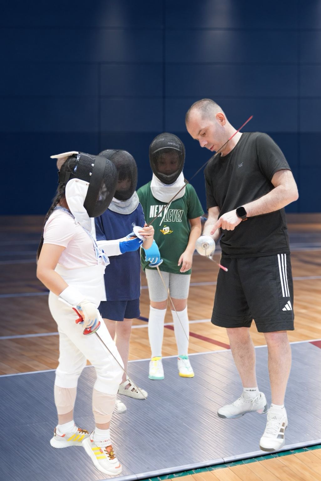 Coach Yousef Alaghehband coaching young fencers